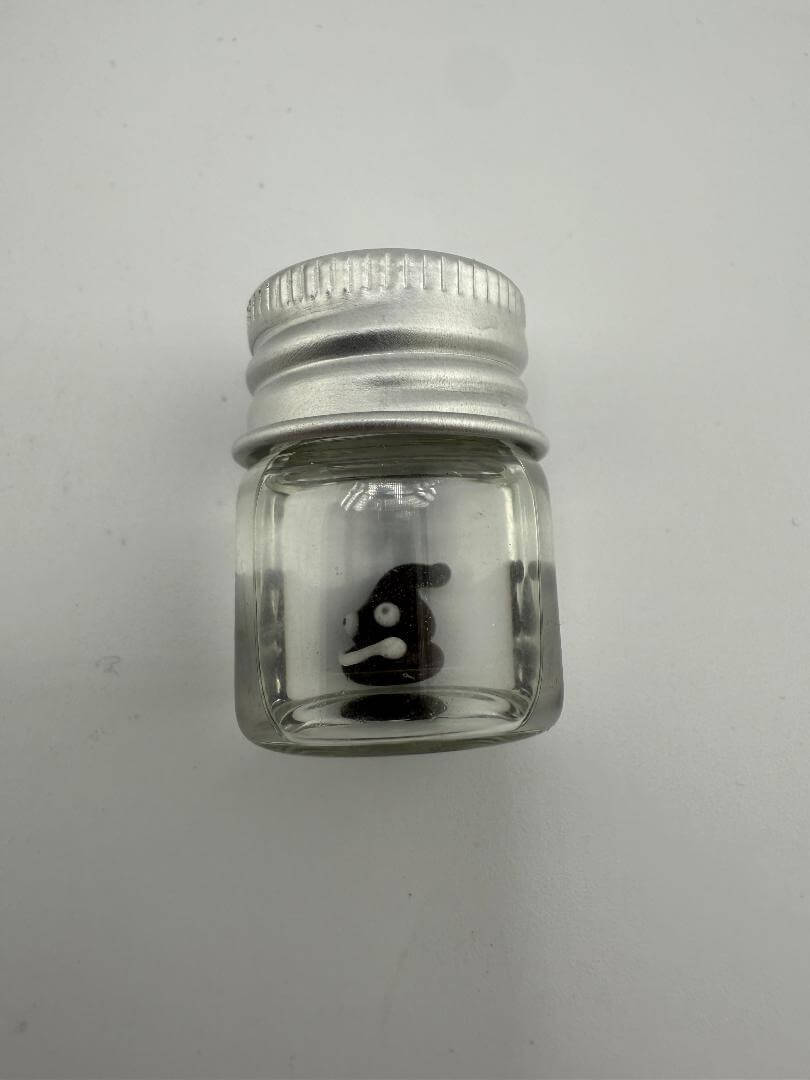 Lucky Gnome Glass Terp Pearl in a clear glass jar with a silver lid, featuring a playful poop emoji design.