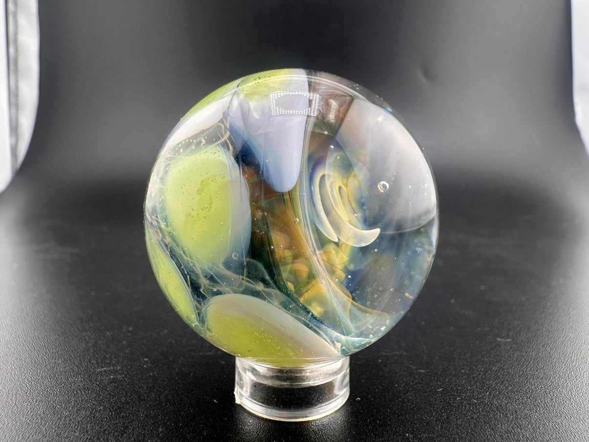 Mop Head Glass Marble - Fumed Implosion Swirl with vibrant colors and swirling design on a display stand.