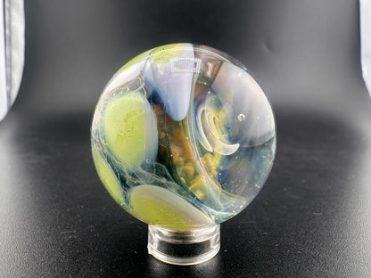 Mop Head Glass Marble - Fumed Implosion Swirl with vibrant colors and swirling design on a display stand.