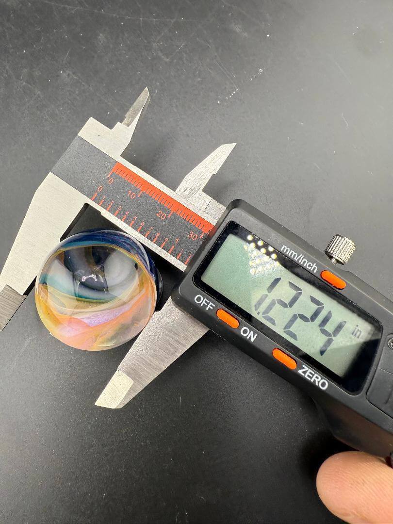 Mop Head Glass Marble - Pastel Vortex 1.2" - 1.5" being measured with calipers, showcasing its unique swirl and dimensions.