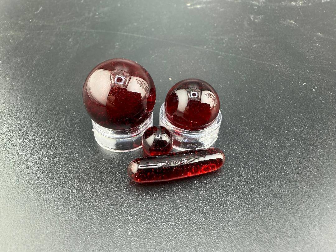 Mop Head Glass Slurper Quartz Terp Pearl Set featuring three red terp pearls on a black surface.