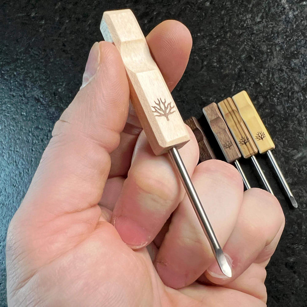 Mystic Timber Dab Tool - Pocket Pick held in hand, showcasing its elegant wood design and precision dab tool functionality.