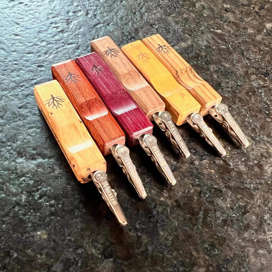 Collection of Mystic Timber Pocket Roach dabbers showcasing various wood finishes and ergonomic designs.