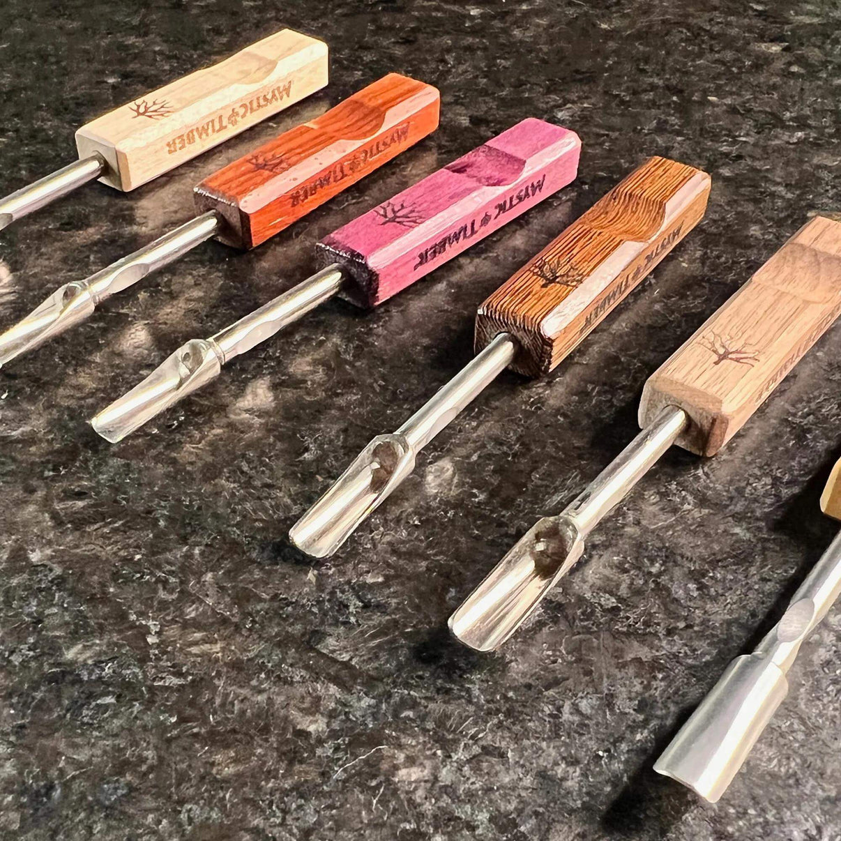 Mystic Timber Dab Tool - Pocket Scoop variety of handcrafted dabbers displayed on a dark surface.