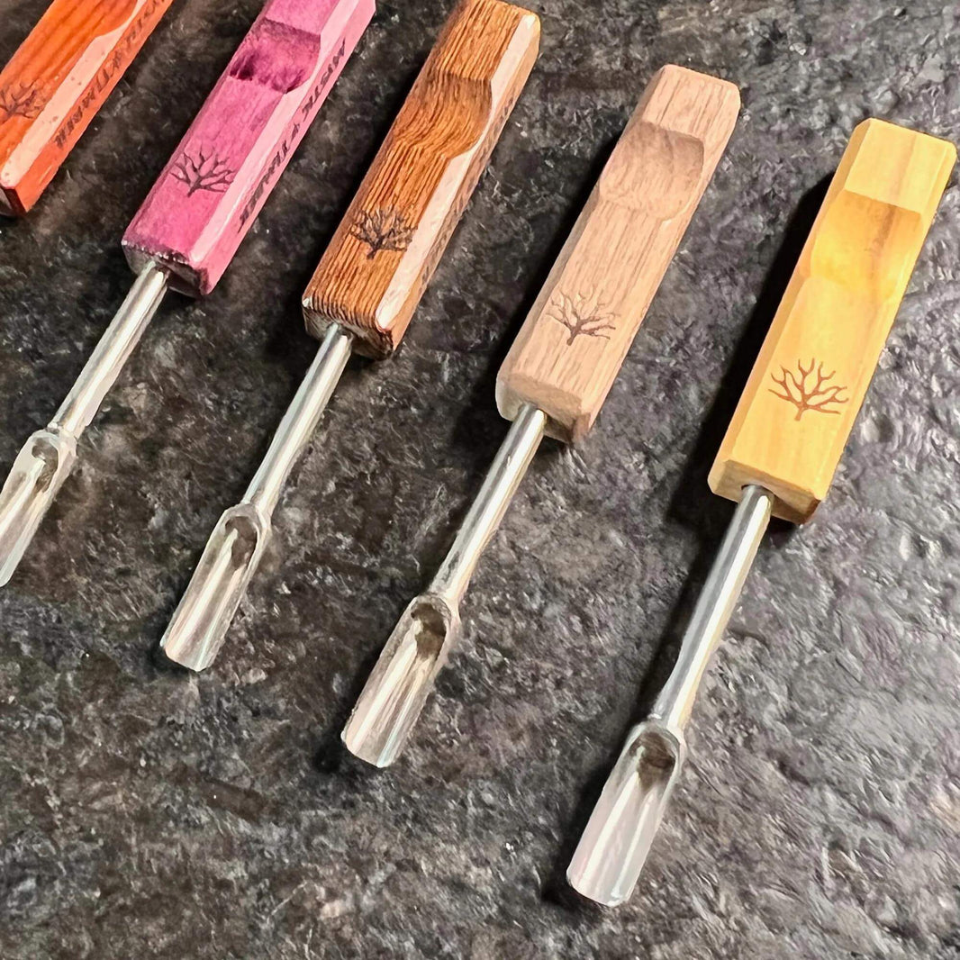 Mystic Timber Dab Tool - Pocket Scoop collection of handcrafted dabbers in various wood finishes on a dark surface.