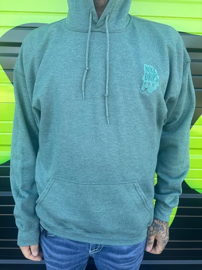 Nikk Drips Hoodie displayed on model against a vibrant green background, showcasing heavy blend comfort and style.