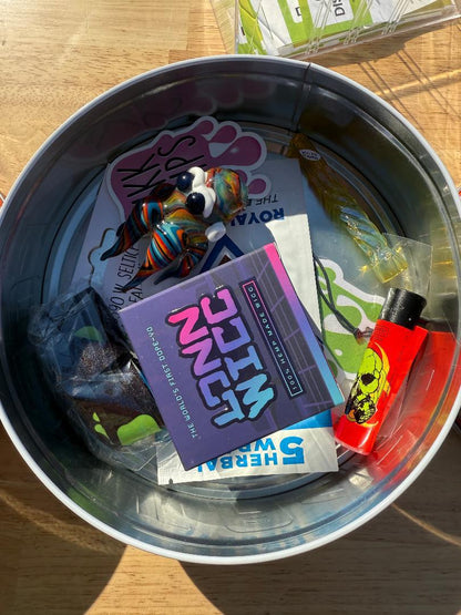 Nikk Drips Mystery Box Tins - Flower Based contents including a chillum, pipe, stickers, and a lighter.