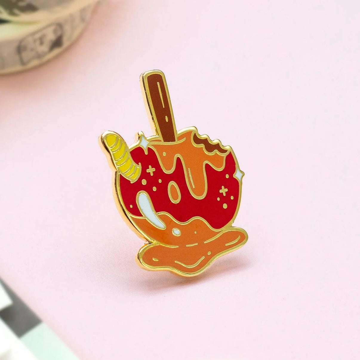 Occasionalish Enamel Pin - Caramel Apple design featuring a candy apple with a caramel coating and a gummy worm.