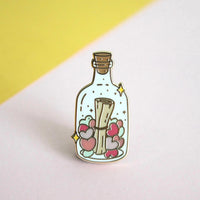 Occasionalish Enamel Pin - Message In A Bottle design featuring a note surrounded by hearts in a glass bottle.
