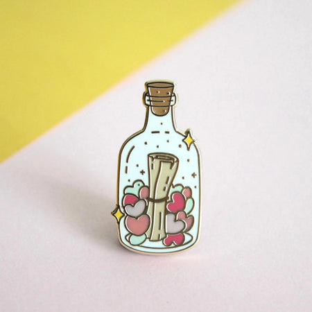 Occasionalish Enamel Pin - Message In A Bottle design featuring a note surrounded by hearts in a glass bottle.