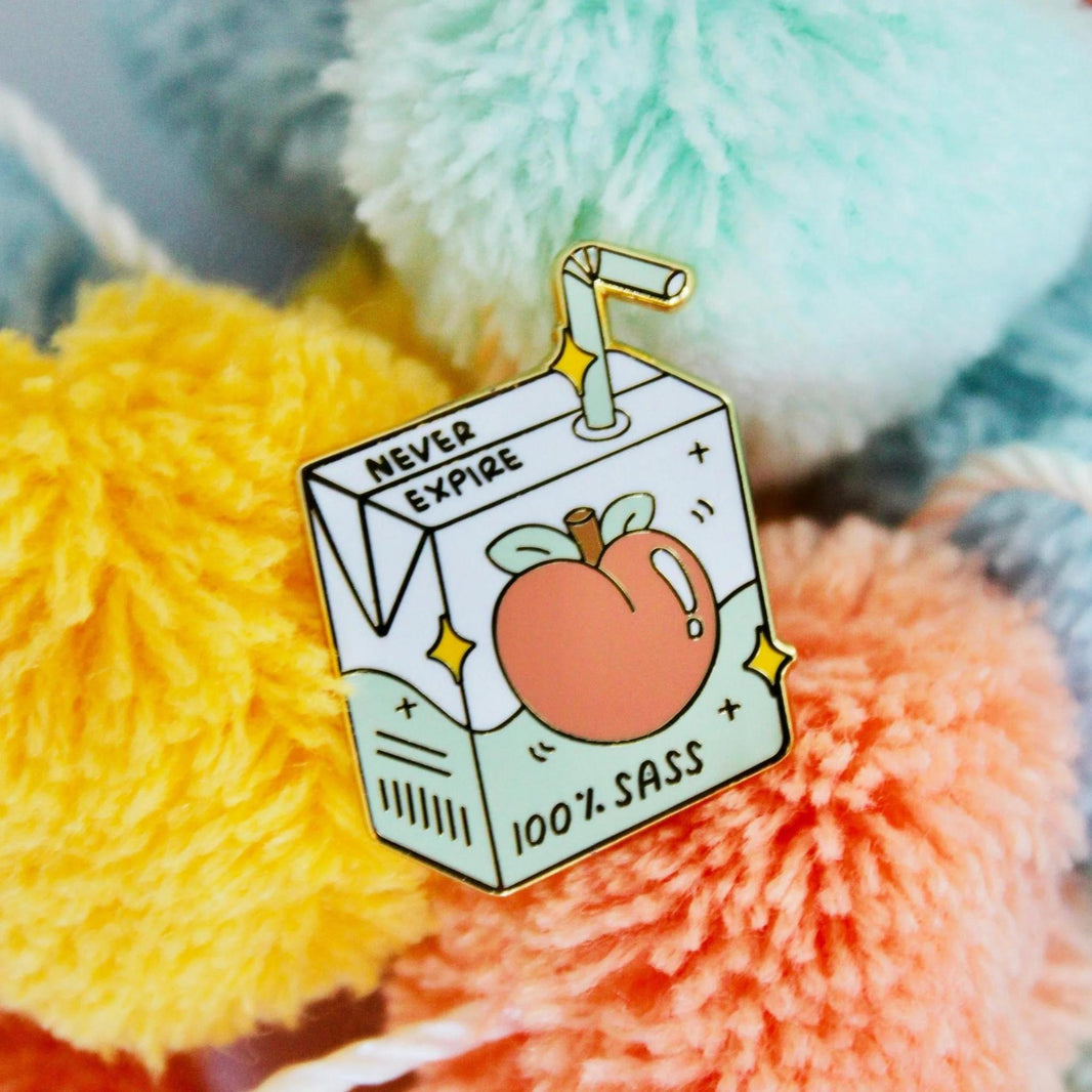 Occasionalish Enamel Pin - 100% Sass on colorful pom poms, showcasing bold and stylish design.