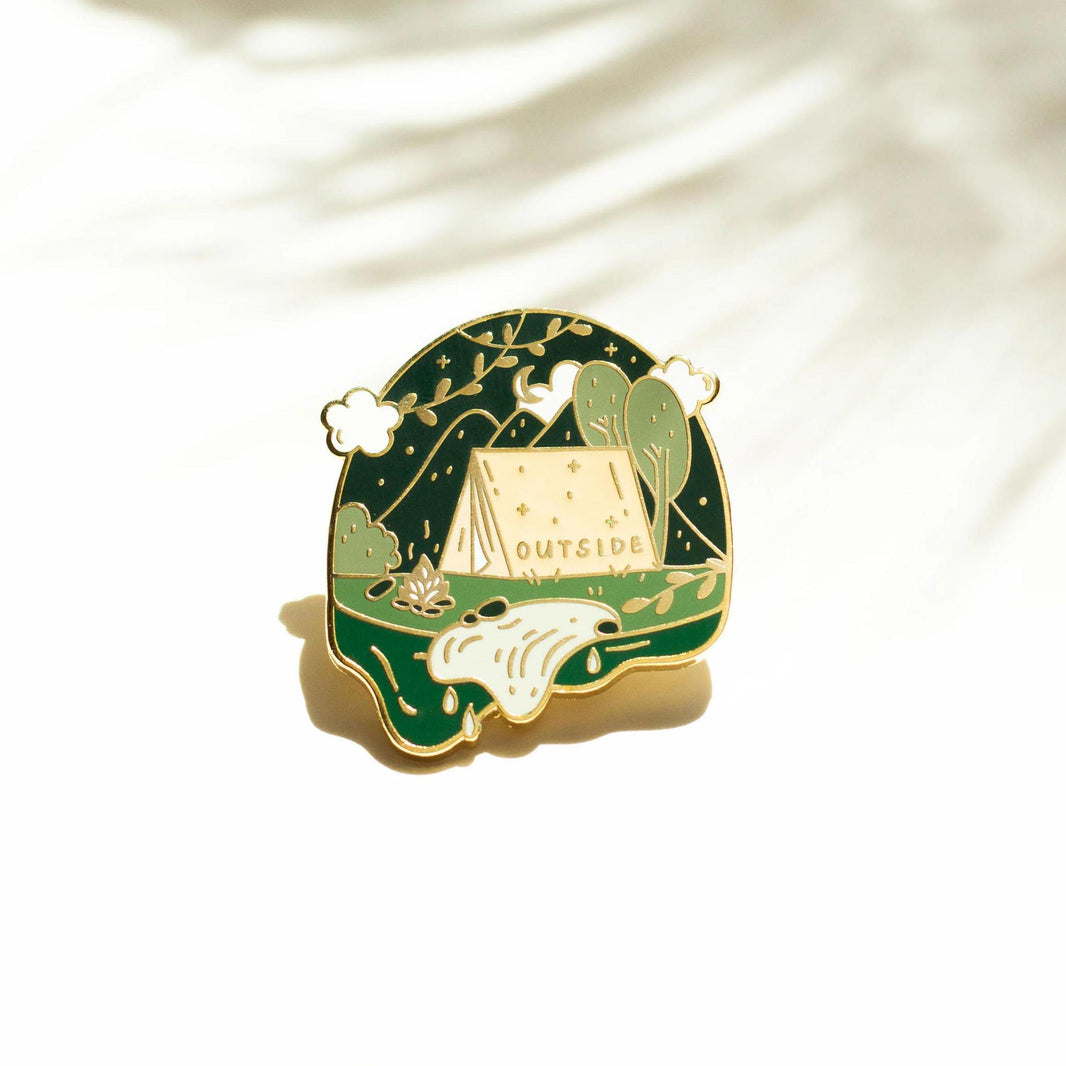 Occasionalish Enamel Pin - Campsite featuring a tent and greenery with the text 'OUTSIDE'.