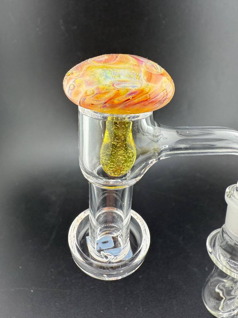 Pablos Glass Mushroom Terp Slurper Cap atop a dab rig, showcasing vibrant colors and unique design for optimal airflow.