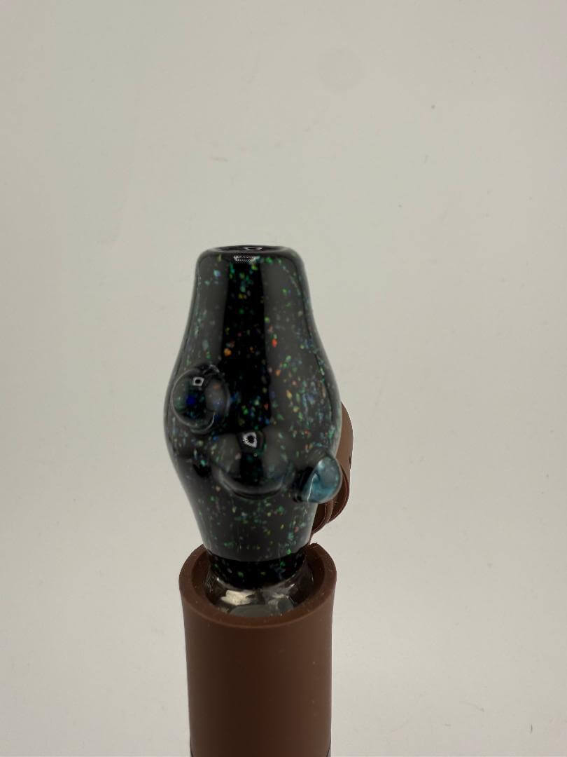 Close-up of a black glass Puffco attachment with colorful speckles, designed for dabbing use.