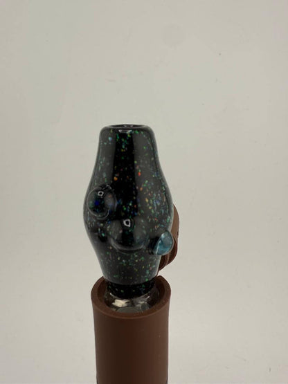 Close-up of a black glass Puffco attachment with colorful speckles, designed for dabbing use.