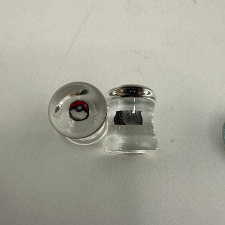 Paulson Pieces 8mm ear plugs featuring Pokeball design, handcrafted borosilicate glass, unique style for stretched ears.