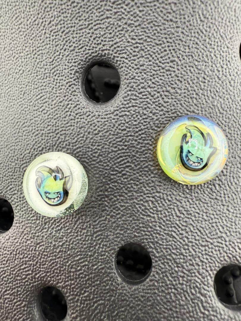 Close-up of Paulson Pieces Glass Kroc Giblets with pop culture icons, handcrafted glass accessories.
