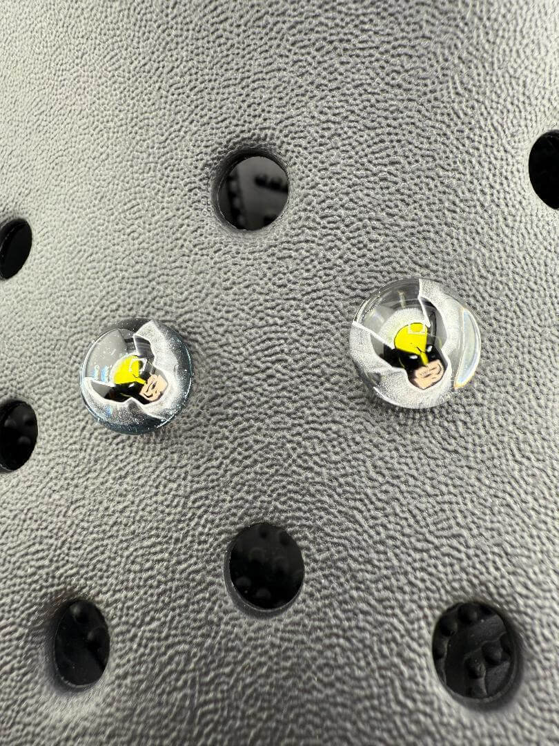 Close-up of Paulson Pieces Glass Kroc Giblets featuring pop culture designs on a textured surface.