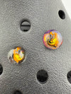 Close-up of Paulson Pieces glass Kroc giblets featuring pop culture designs on a textured black surface.