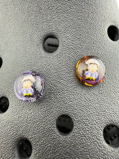 Two handcrafted Paulson Pieces Glass Millie Kroc Giblets featuring pop culture designs on a textured background.