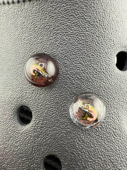 Close-up of Paulson Pieces glass Kroc giblets with pop culture designs, showcasing intricate details and colors.