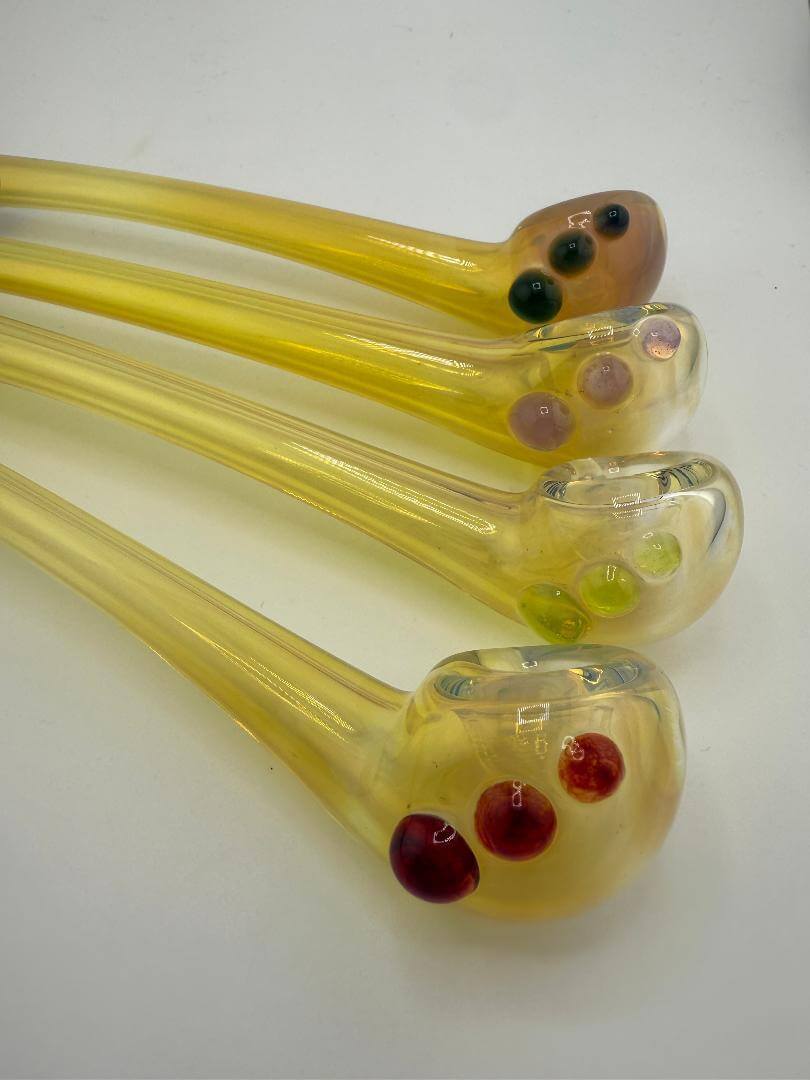 Set of four handcrafted yellow glass pipes with colorful accents, showcasing elegant long designs.
