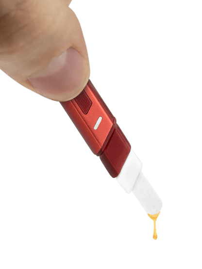 Puffco Hot Knife heating tool in hand, with extract dropping from the ceramic tip.