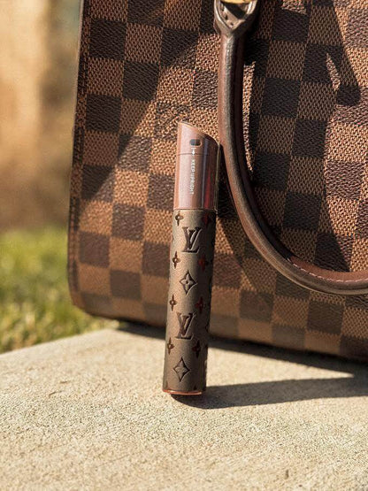 Puffco X Palmers Powders Pivot - LV Power Coated next to a stylish Louis Vuitton handbag on a sunny day.