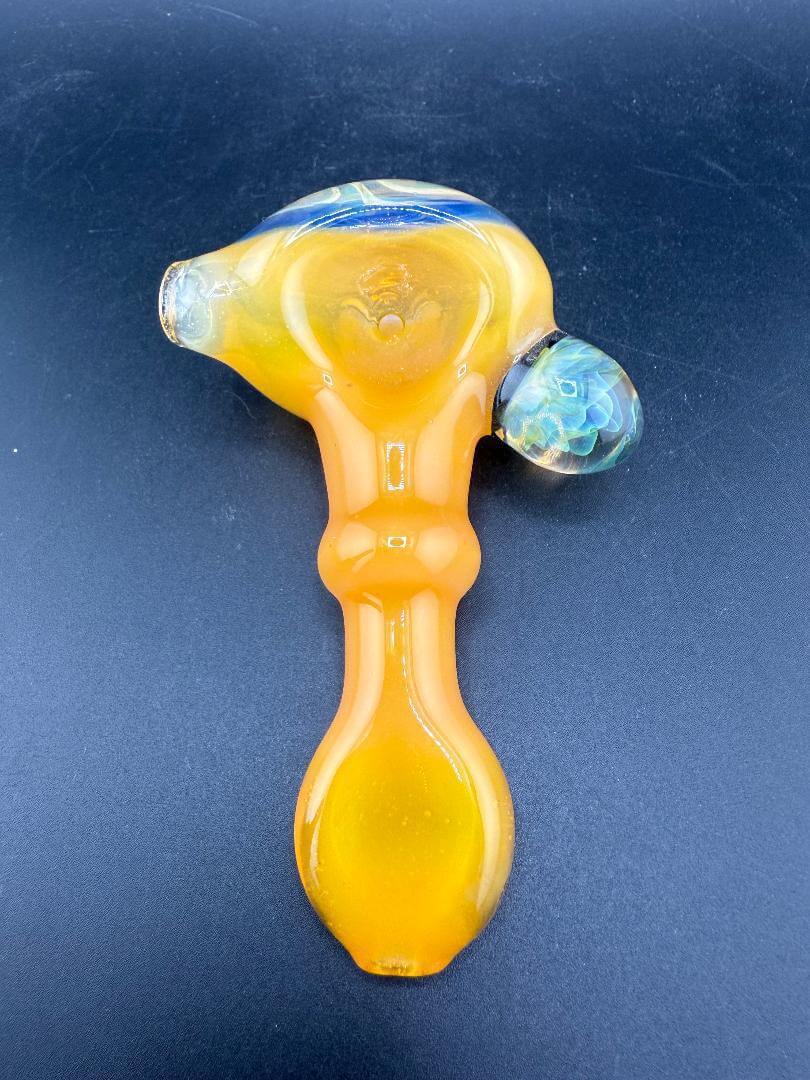 Pugsley Glass Hand Pipe - Orange w/ Fumed Cap & Marble Attachment viewed from above against a black background.