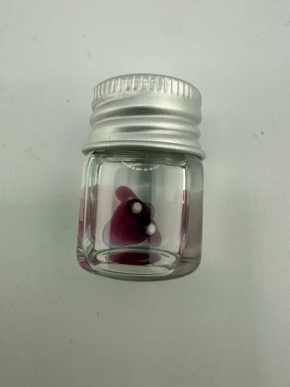 Lucky Gnome Glass Terp Pearl in a clear jar with a silver cap, featuring a playful purple design.