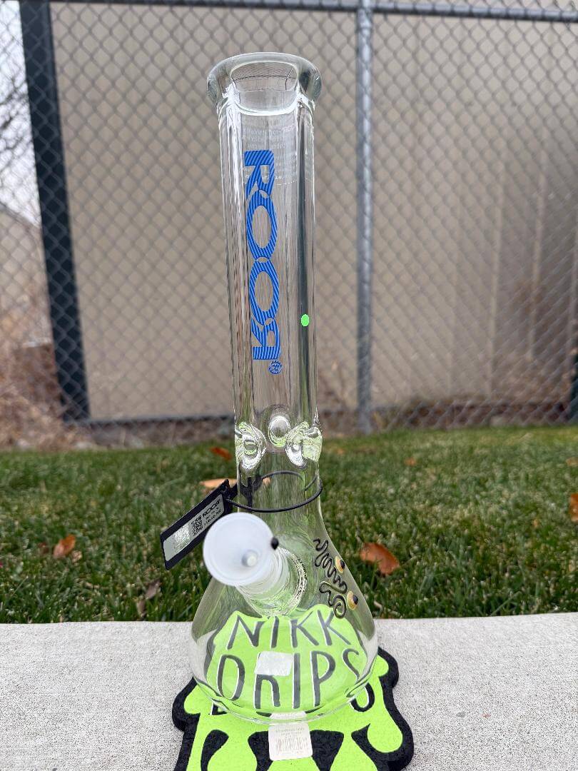 ROOR Glass14" Beaker 50 x 9mm Thick - Blue displayed on grass with a vibrant design and branding.