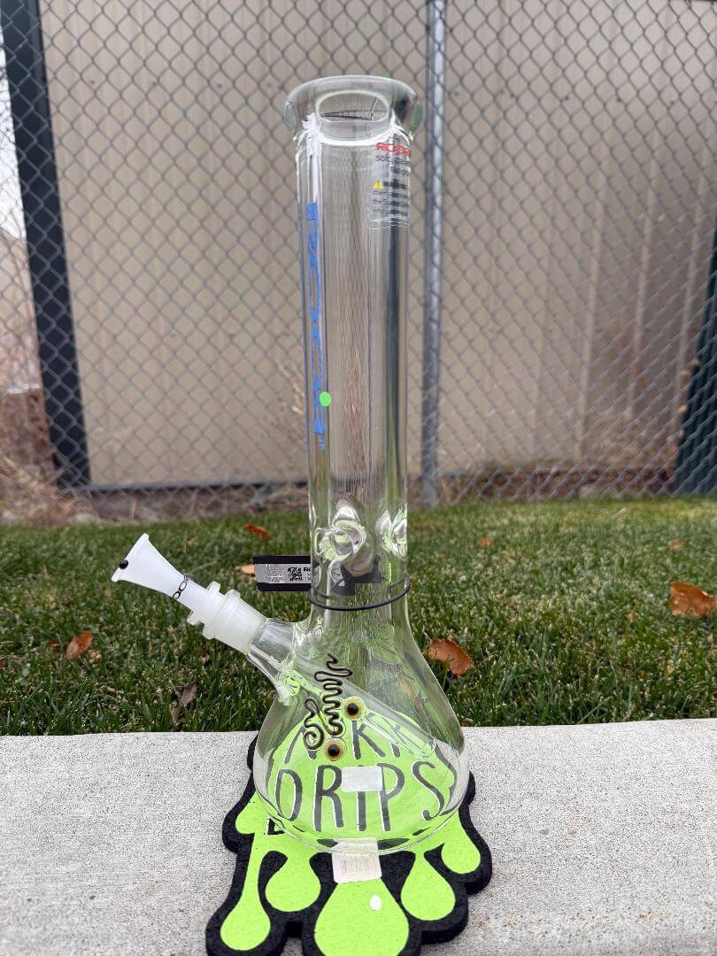 ROOR Glass14" Beaker 50 x 9mm Thick - Blue displayed on a green mat with a stylish design.