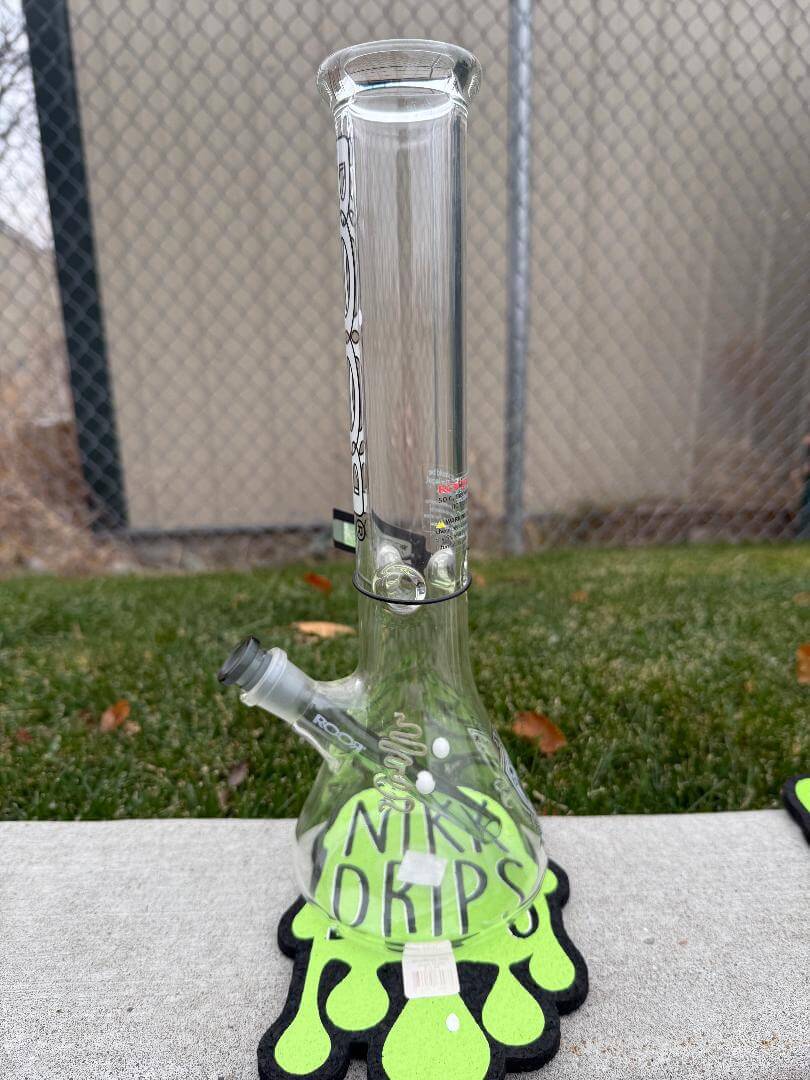 ROOR Glass 14" Beaker 50x5mm Collector Series Beaker - Smoke displayed on green drip mat with background fence.