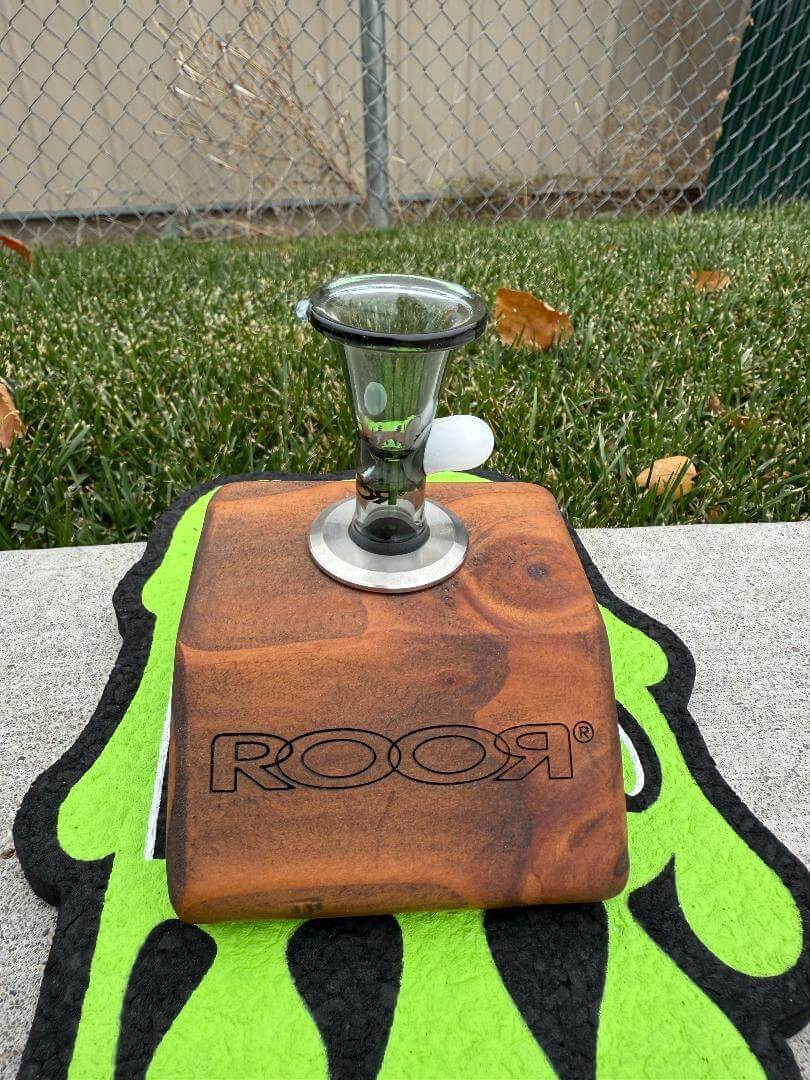 ROOR Glass 14" Beaker 50x5mm Collector Series Beaker - Smoke displayed on a wooden stand with a glass bowl.