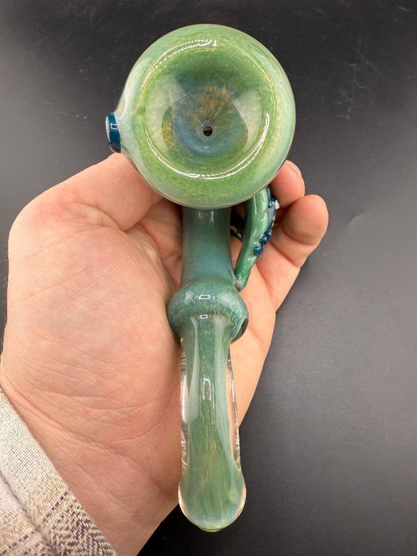 Rosie Works Sherlock Pipe - Green Frit w/ Leaf & Blue Frog Attachment held in hand, showcasing design and craftsmanship.