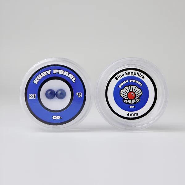 Ruby Pearl Co Terp Pearls – Ruby & Sapphire 4mm AAA Lab-Grown Gemstones (2-Pack) in packaging.