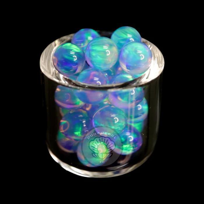 Ruby Pearl Co Terp Pearls - Opal 5mm in a glass container showcasing vibrant color play.