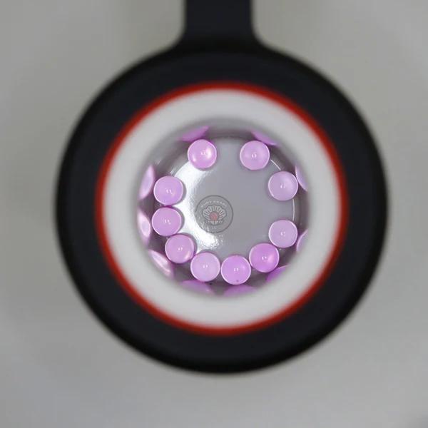 Ruby Pearl Co Terp Pearls – Ruby & Sapphire 3mm AAA Lab-Grown Gemstones (10-Pack) seen through a magnifying lens.