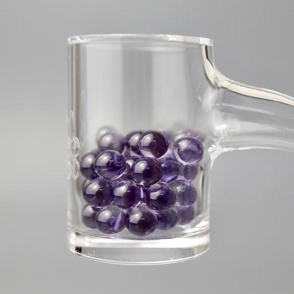 Ruby Pearl Co Terp Pearls - Ruby & Sapphire 5mm displayed in a clear quartz banger, showcasing their vibrant color and design.