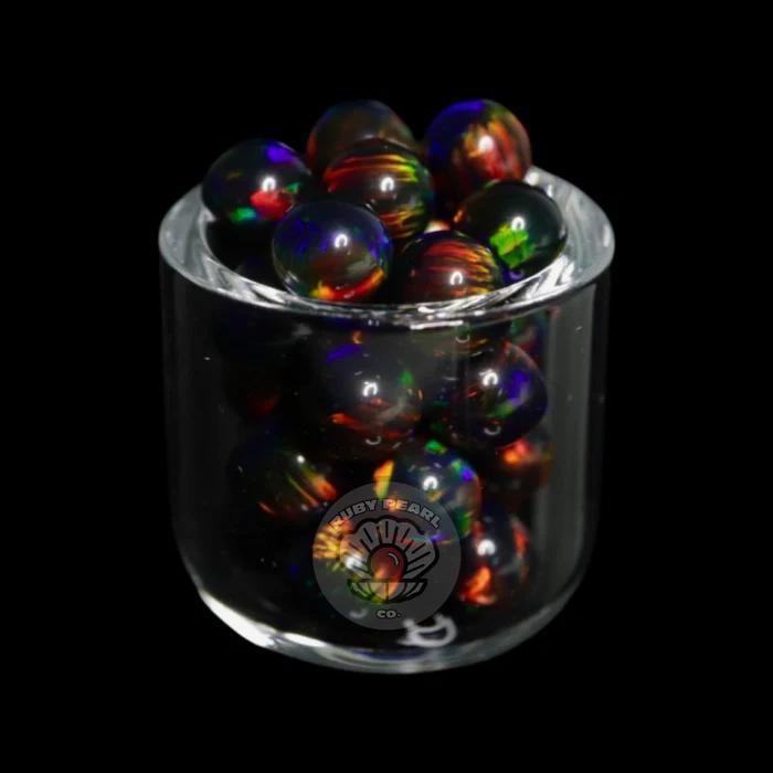 Ruby Pearl Co Terp Pearls - Opal 5mm displayed in a glass container, showcasing vibrant colors and design.