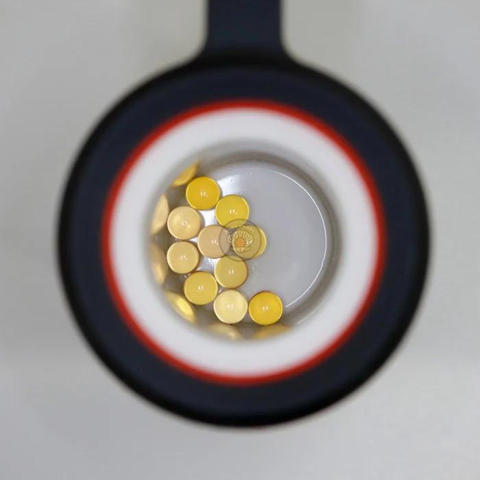 Ruby Pearl Co Terp Pearls – Ruby & Sapphire 3mm AAA Lab-Grown Gemstones (10-Pack) viewed through magnifying lens.
