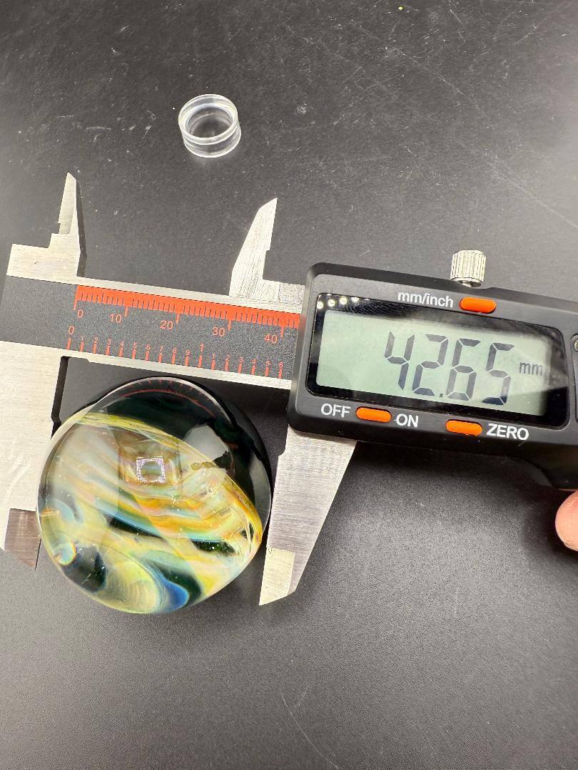 Siliceous Boro Jockey (SBJ) Marble - 42mm UV Retti Cello w/ UV Dot Stack Backer being measured at 42.66mm.