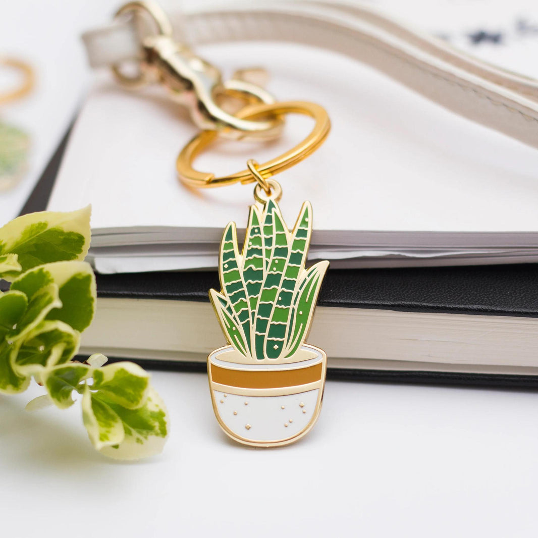 Occasionalish Keychain - Snake Plant featuring a gold enamel keychain with a snake plant design.