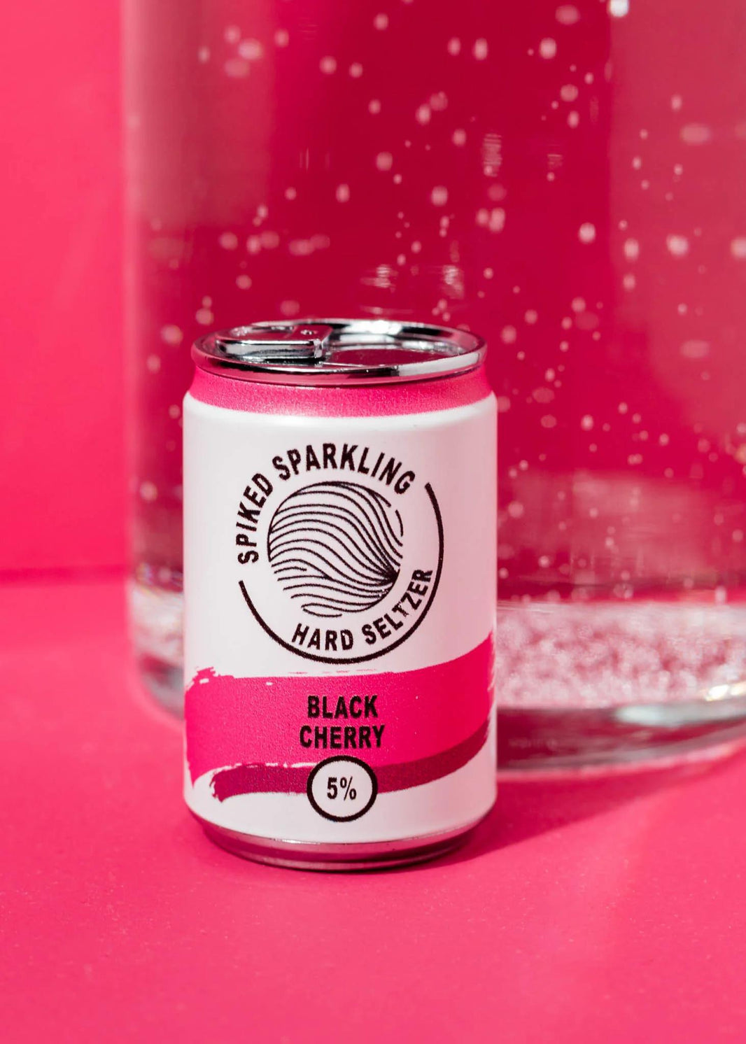 Canna Style Lighter - Spiked Seltzer displayed next to sparkling water with a pink background.