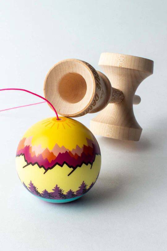 Sweets Kendama Joshua 'Flow' Grove Pro mod with colorful ball and wooden tama, showcasing vibrant mountain design.