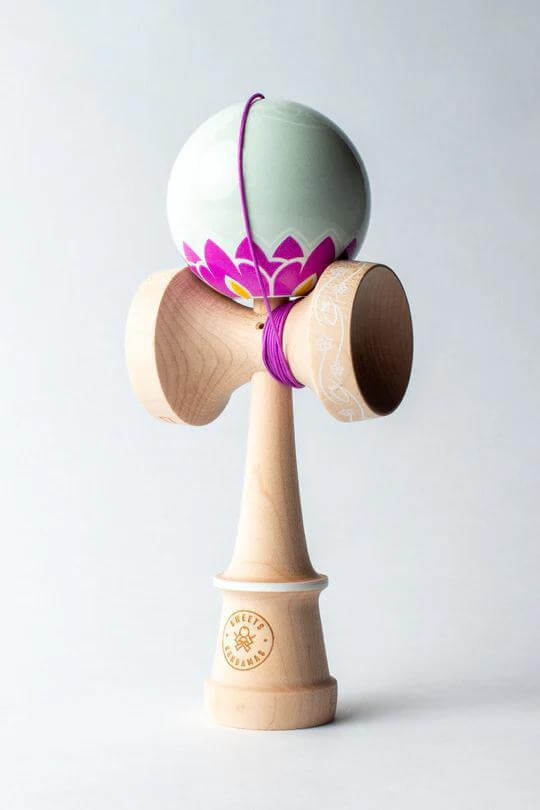 Sweets Kendama Nonoka Kyodo Amped Sticky Clear kendama with floral design and wooden base.