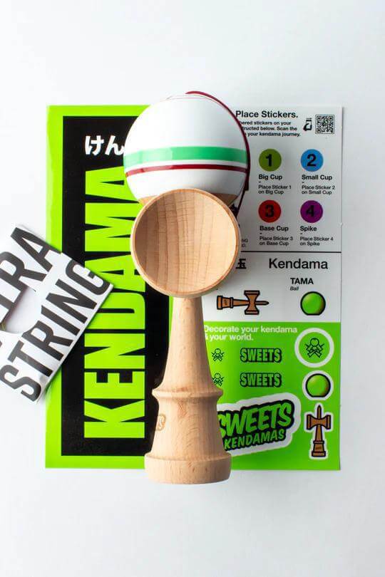 Sweets Kendama Sport Stripe Sticky Clear with stickers and extra string on a bright background.
