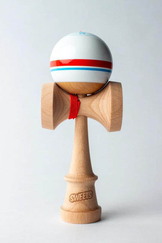 Sweets Kendama Sport Stripe in Sticky Clear finish, showcasing a wooden base and striped ball design.