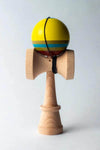 Sweets Kendama Triple Stripe with yellow tama and blue stripes on a wooden handle, showcasing modern design.