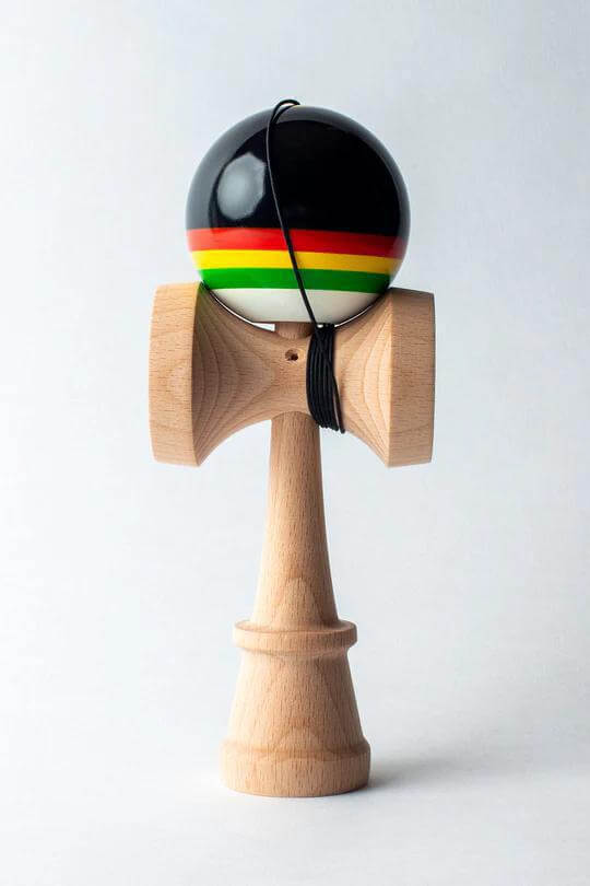Sweets Kendama Triple Stripe Legend Sticky Clear with vibrant black and colored stripes, featuring full beech construction.